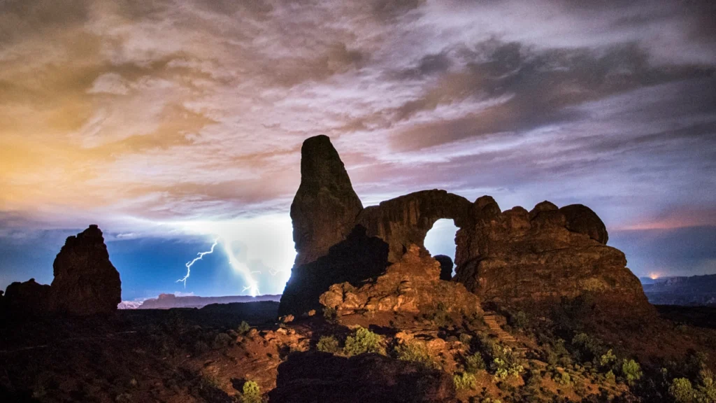 Dramatic lightning strike illuminates a sandstone rock formation in Arches National Park, Utah.