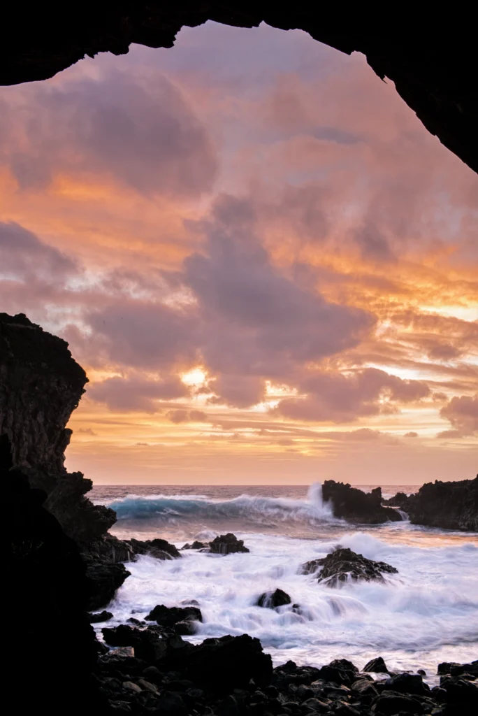 View of the Pacific Ocean at sunset from inside Ana Kai Tangata, a cave on Easter Island.