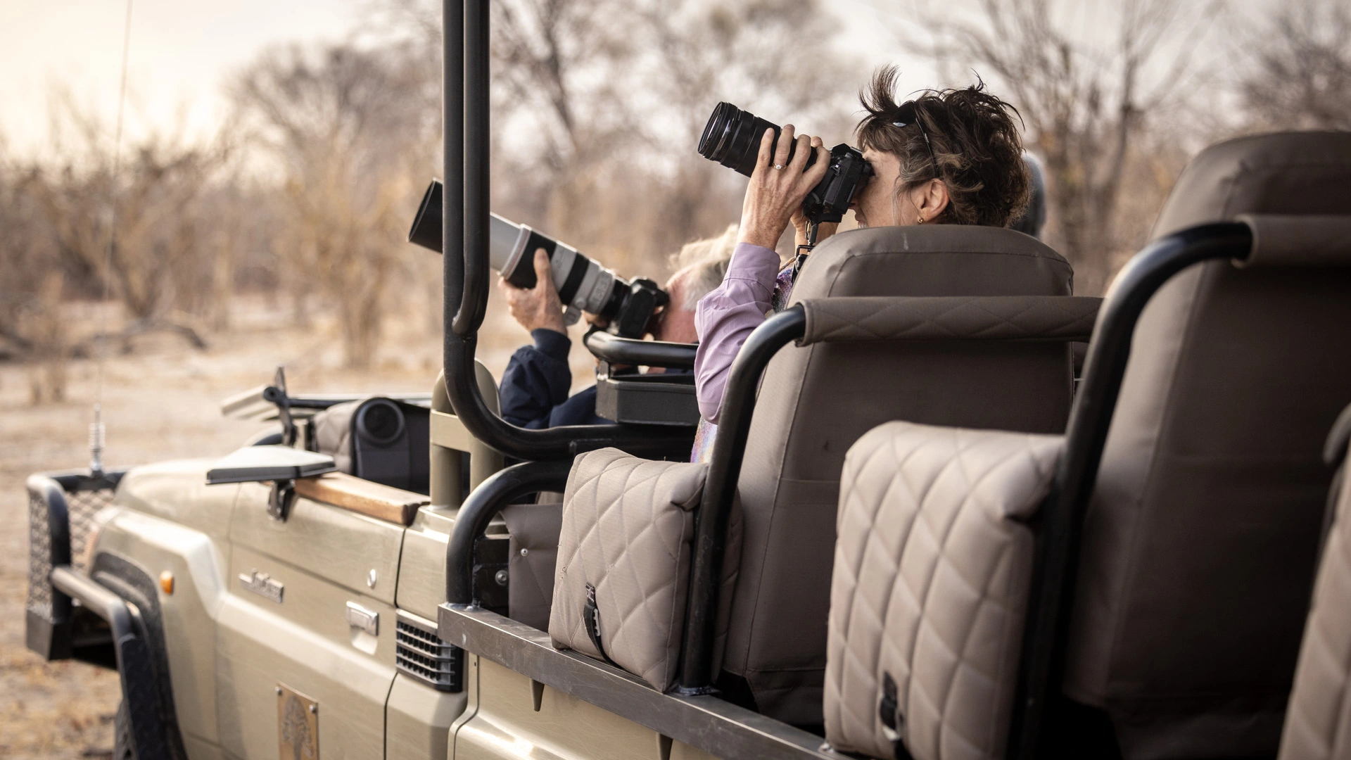 Photograph of a safari vehicle with photographers taking photos