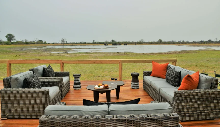 Relax on the deck at Nogatsaa Pans Lodge with elephants in the background.